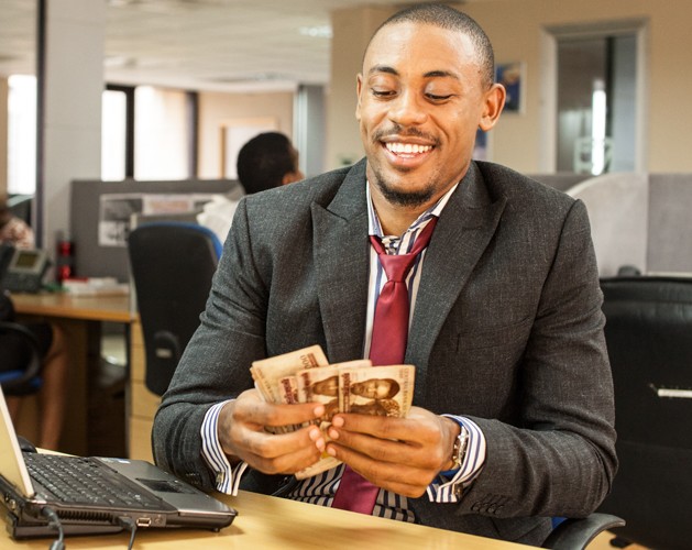 A man counting money and smiling.